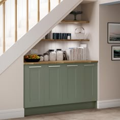 a kitchen under the stairs with bookshelves and other items on top of it