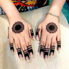 two hands with hendi designs on them, one is black and the other is white