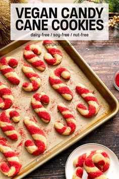 vegan candy cane cookies on a cookie sheet with red sugar sprinkles