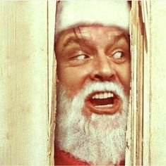 an old man wearing a santa claus hat looking through a window with his mouth wide open