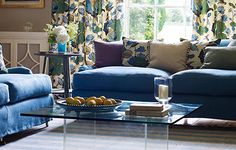 a living room filled with blue couches and pillows