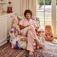 a man sitting in a chair with his feet up on the floor next to a window