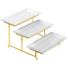 three white trays with gold legs on each side