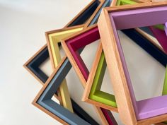 multicolored wooden frames stacked on top of each other in the shape of an octagon