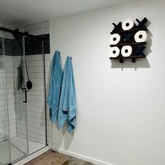 a bathroom with towels hanging on the wall and a towel rack in front of it