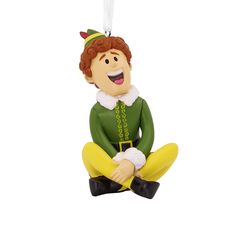 a christmas ornament with a man in green and yellow outfit sitting on the ground