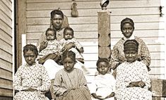 an old black and white photo of women with babies on their laps, sitting in front of a house