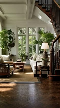 a living room filled with lots of furniture next to a stair case in front of a window