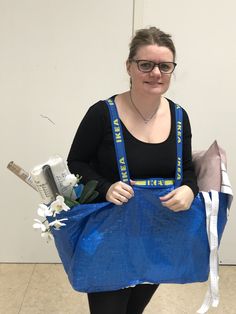 a woman holding a blue bag with flowers in it