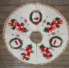 a white table cloth with christmas decorations and bells on it, sitting on a wooden floor