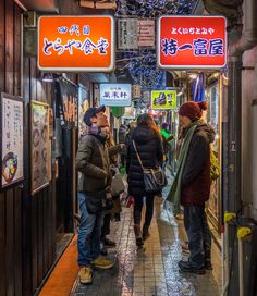 people are walking down an alley way with signs above them that read, happy new year