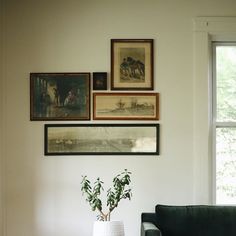 a living room with pictures on the wall and a couch in front of it,