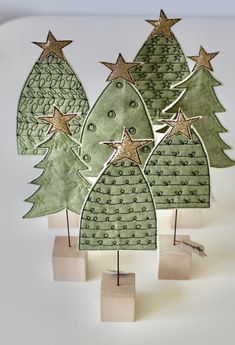 three wooden christmas trees with gold stars on them, one is green and the other is white