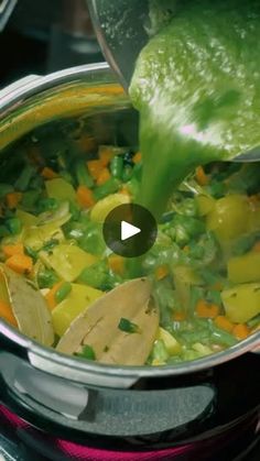 a pot filled with vegetables being stirred by a ladle