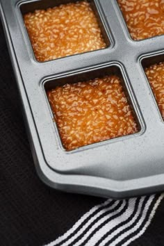 four square trays filled with food sitting on top of a table