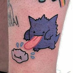 a person with a tattoo on their leg has an image of a cat and rainbow