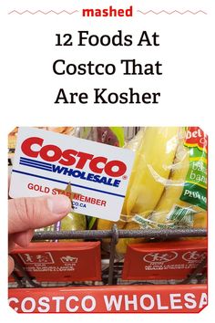 a person is holding up a costco card in front of a grocery store display