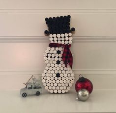 a snowman made out of toilet paper and some christmas decorations on top of a shelf