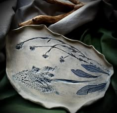 a ceramic dish with leaves and flowers on it