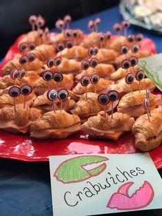 some croissants with googly eyes on them sitting on a red plate