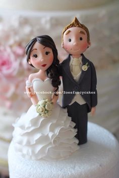 a bride and groom figurine on top of a wedding cake