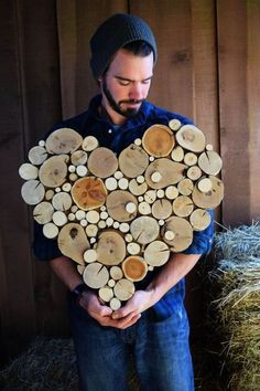 a man holding a heart made out of logs