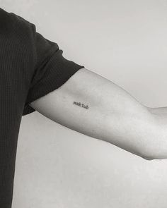 a man with a tattoo on his arm that reads, just ask me in black and white