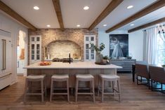 a large kitchen with an island counter and stools in front of the stove top