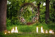 an outdoor wedding ceremony with candles and wreath