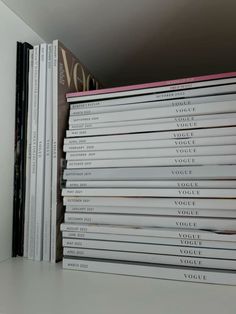 a stack of books sitting on top of a white shelf