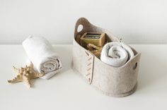 a basket with towels and other items in it on a table next to a starfish