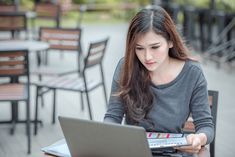 a woman sitting at a table with a laptop and calculator