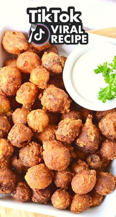 a white bowl filled with fried food next to a dipping sauce