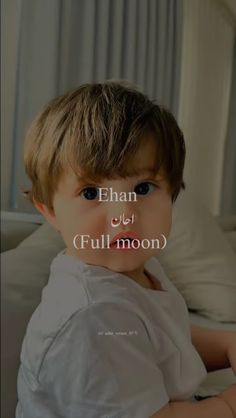 a little boy sitting on top of a bed next to a white pillow with the words ehan and full moon