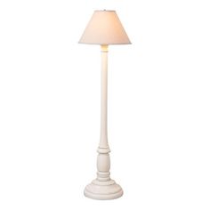 a white floor lamp with a beige shade on the base and a light in the middle