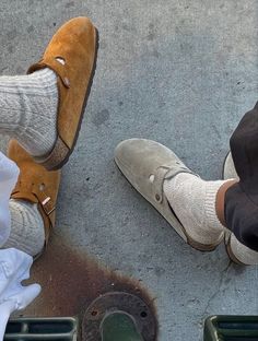 two people standing next to each other with their feet in the ground and one wearing white socks