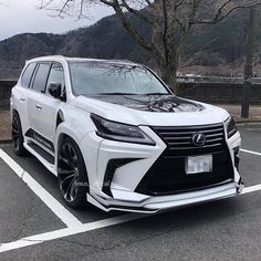 the front end of a white suv parked in a parking lot