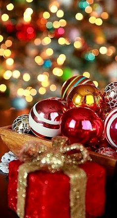 christmas ornaments and presents on a table in front of a tree