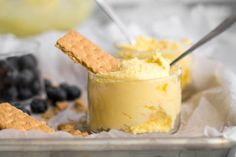 a bowl filled with ice cream next to crackers and blueberries