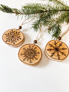 three wooden ornaments hanging from a christmas tree