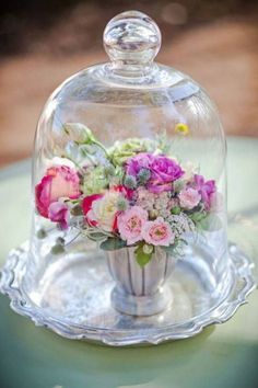 a glass clochel with flowers in it