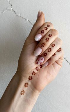 a woman's hand with flowers painted on it