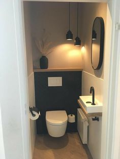 a small bathroom with a toilet, sink and mirror on the wall next to it