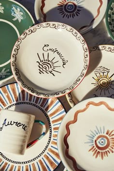 many plates with different designs and writing on them are stacked next to each other in rows