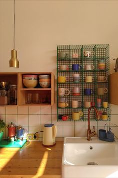 a kitchen area with a sink, counter and shelves