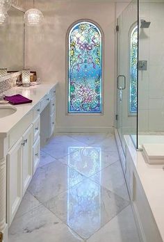 a bathroom with a large stained glass window in the shower and double sinks on both sides