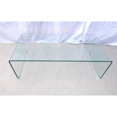 a glass coffee table sitting on top of a carpeted floor