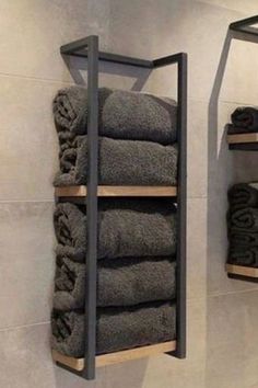 towels are stacked up on shelves in the bathroom, while another shelf holds folded towels