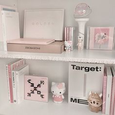 a shelf filled with books and other items on top of it's white shelves