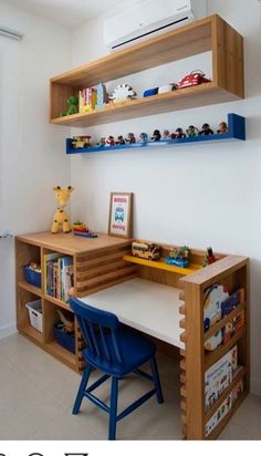 a wooden desk with shelves above it and a blue chair in front of the desk